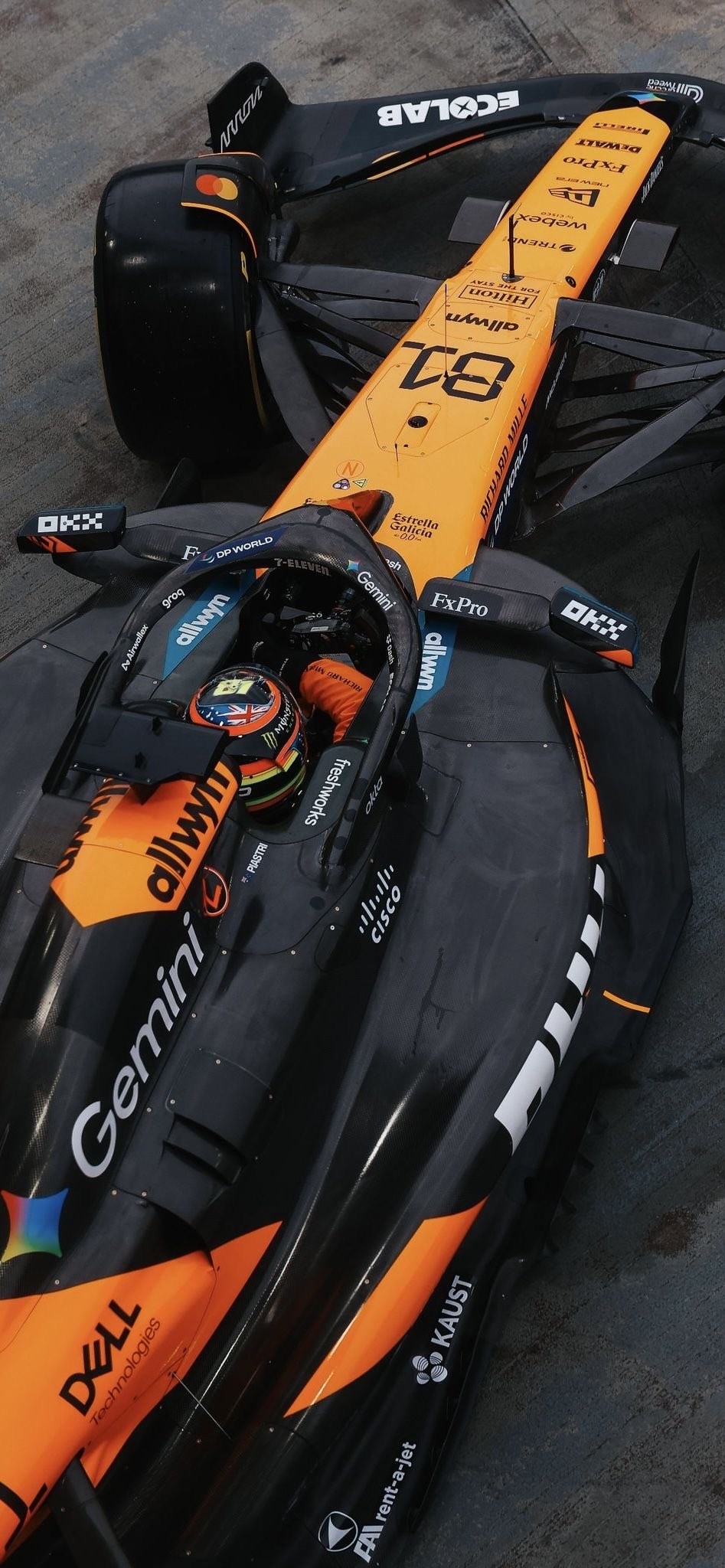 Gros plan d'une voiture McLaren F1 noire et orange avec le pilote dans le cockpit