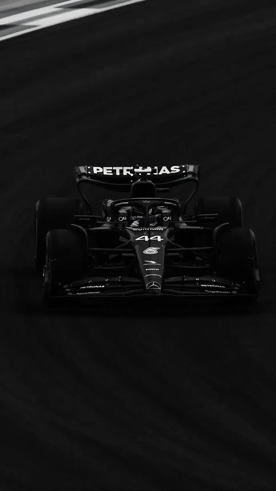 A heavily modified black Mercedes-Benz with wide fender flares and dramatic lighting