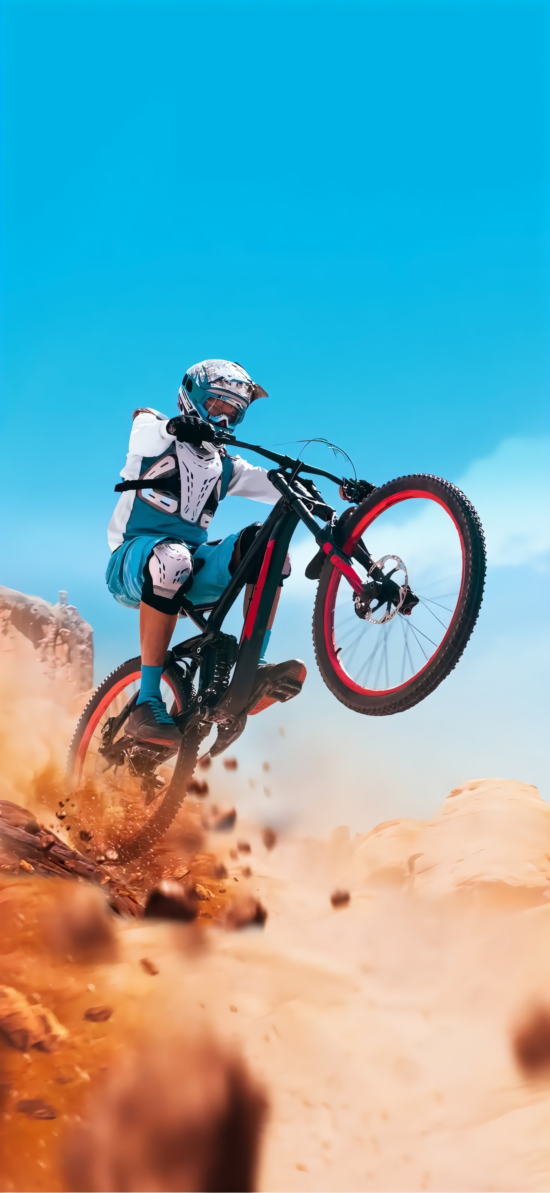 Un ciclista de montaña salta en el aire vistiendo equipo de protección blanco y teal en una bicicleta negra con llantas rojas