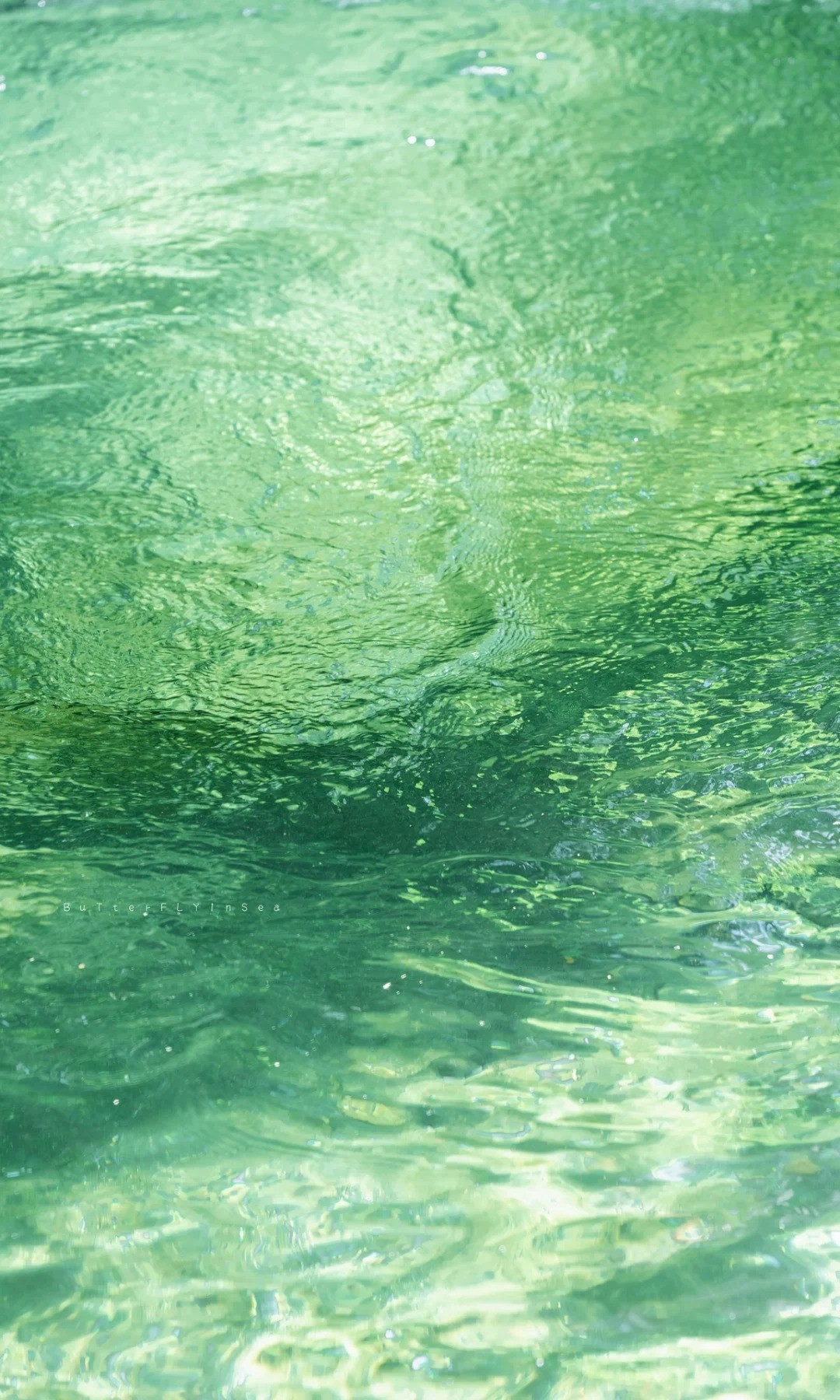 Klarer Wasserspiegel reflektiert Sonnenlicht und schafft schimmernde Muster