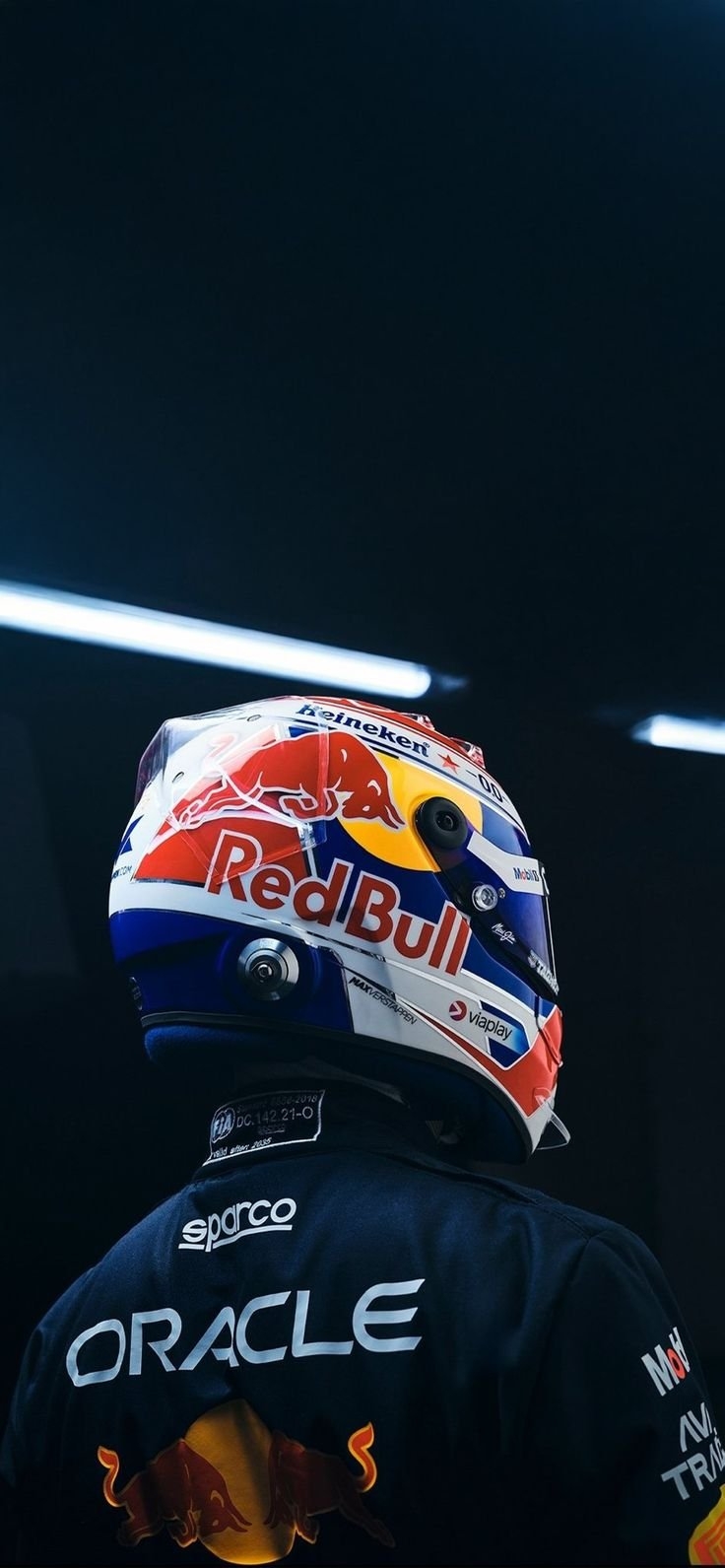 Гонщик в шлеме Red Bull и черном гоночном костюме