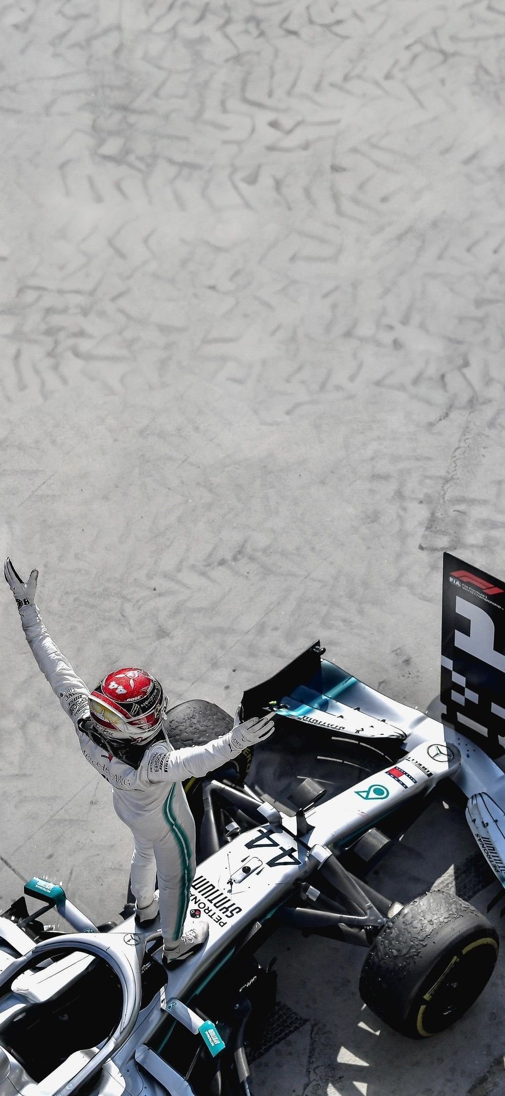 Hamilton celebrates F1 victory in silver racing suit and red helmet