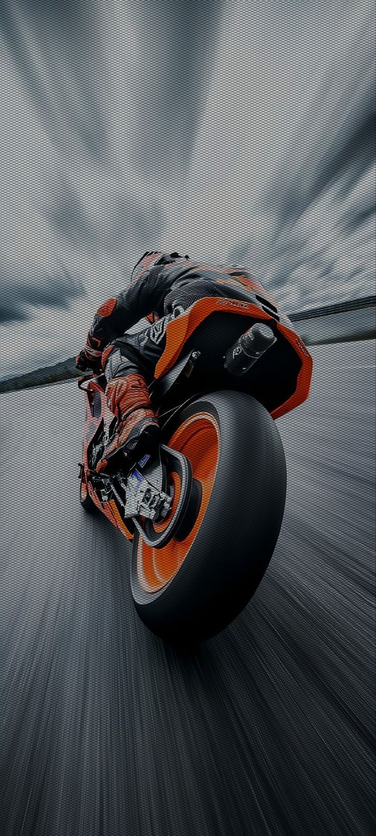 ライダーがオレンジと黒のバイクでサーキットを走行する