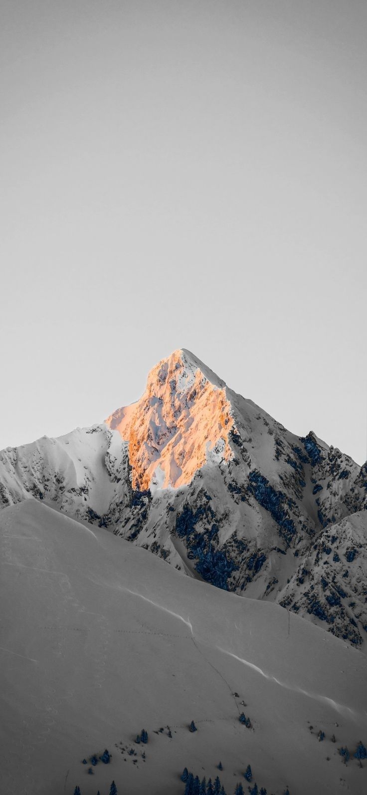 低飽和度的雪山在金色陽光下形成明暗對比