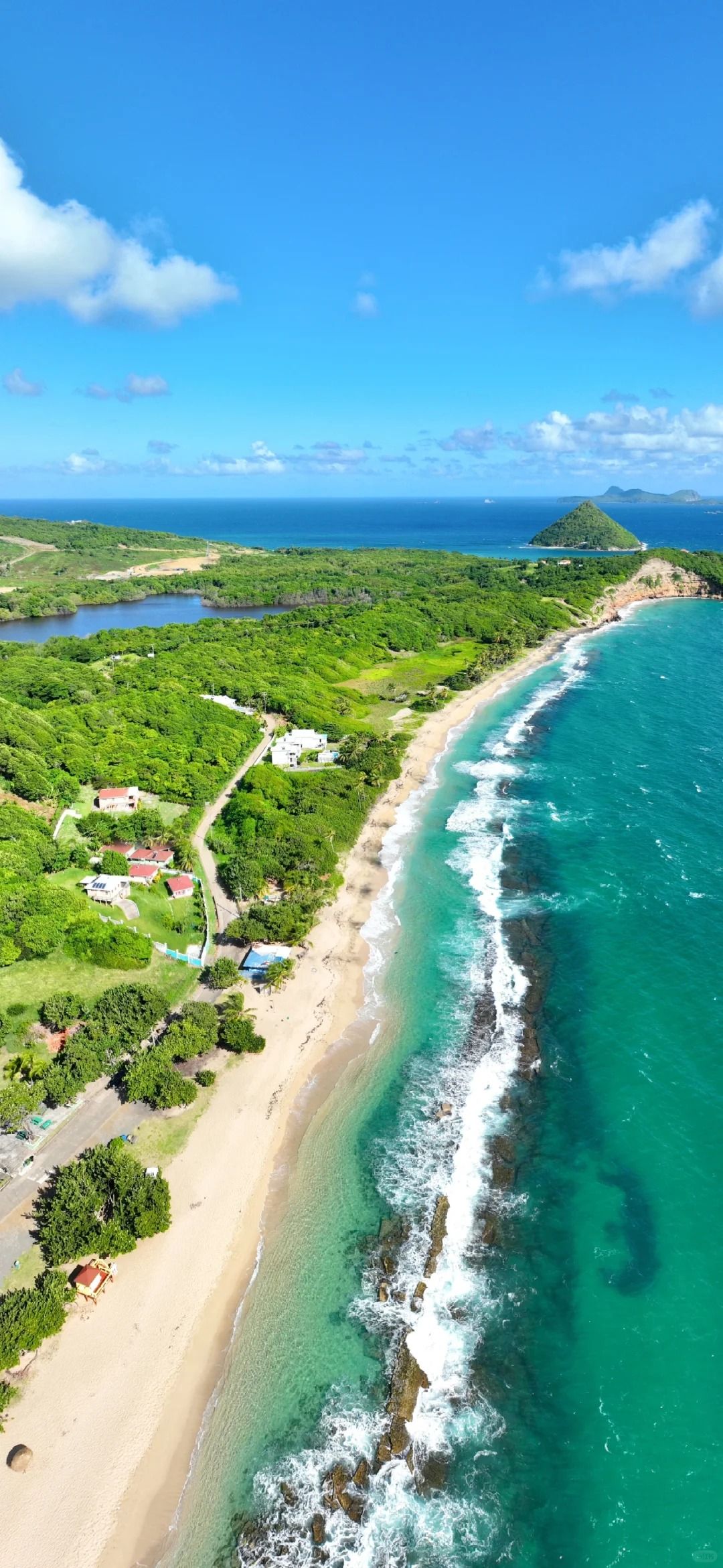 Coastal aerial wallpaper showcases emerald waves and a crescent-shaped beach