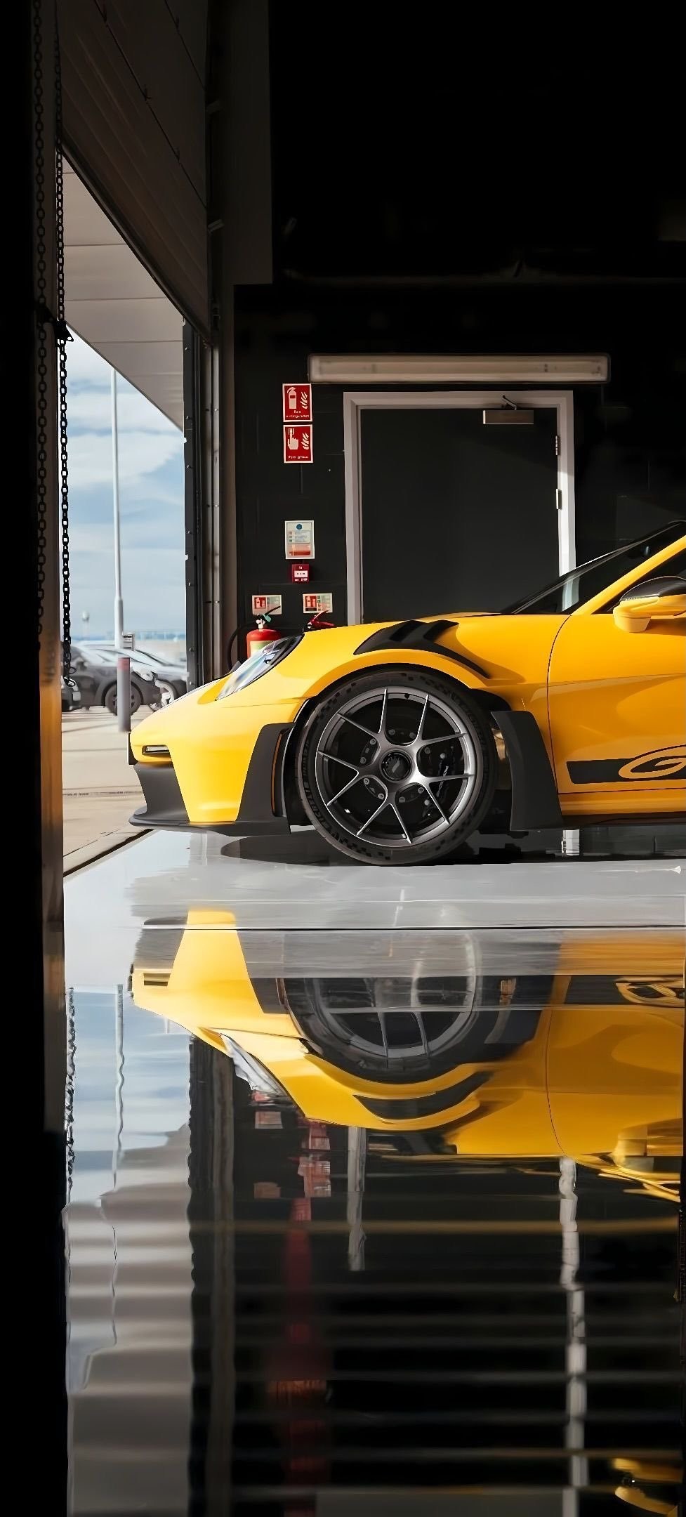 A bright yellow Porsche GT3 RS parked in a garage