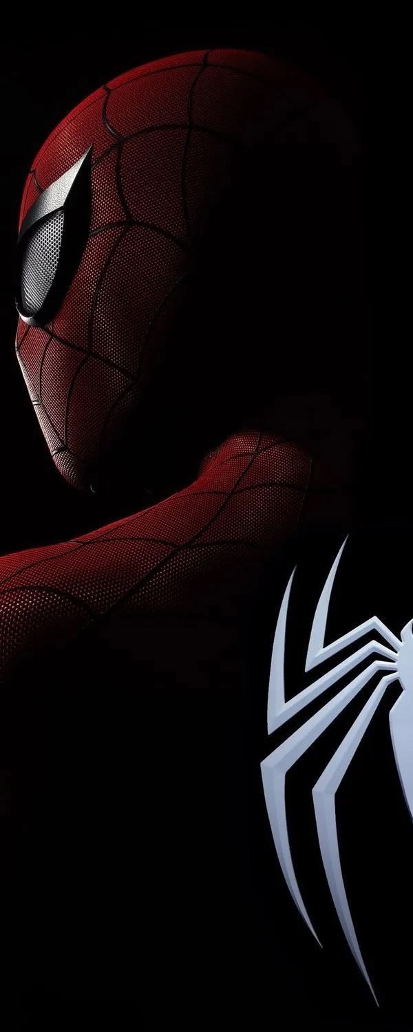 A masked superhero's side profile emerges from darkness, showcasing a red-and-black suit with a white spider emblem signifying mystery and readiness