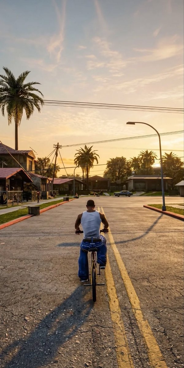 The image shows a muscular man riding a bicycle on a cracked asphalt road, evoking nostalgia and serenity