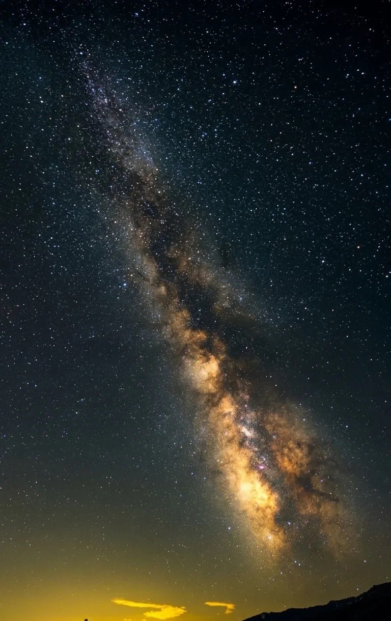 夜空銀河攝影，星星密集，星系斜穿。深黑和深藍底色，金橙和銀白星系核心。對角構圖，低地平線，廣闊深遠的宇宙氛圍。