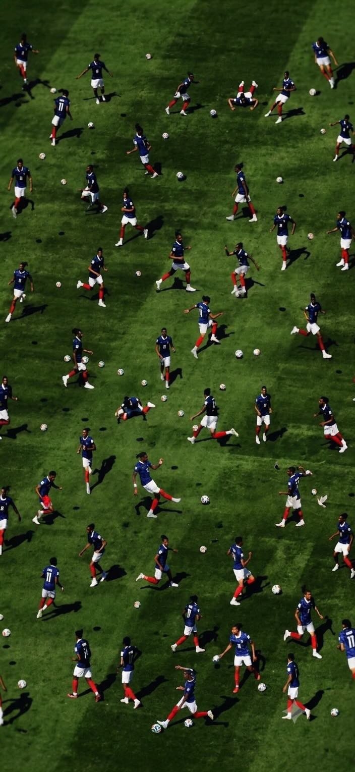足球運動員身穿相同球衣在場地上重複移動，形成圖案效果。