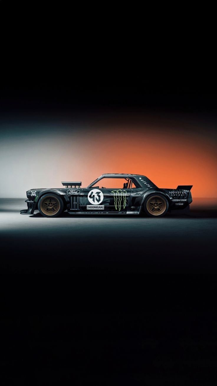 Das ist ein breitkarierter schwarzer Ford Mustang Rennwagen mit Monster Energy und Hoonigan Lackierung