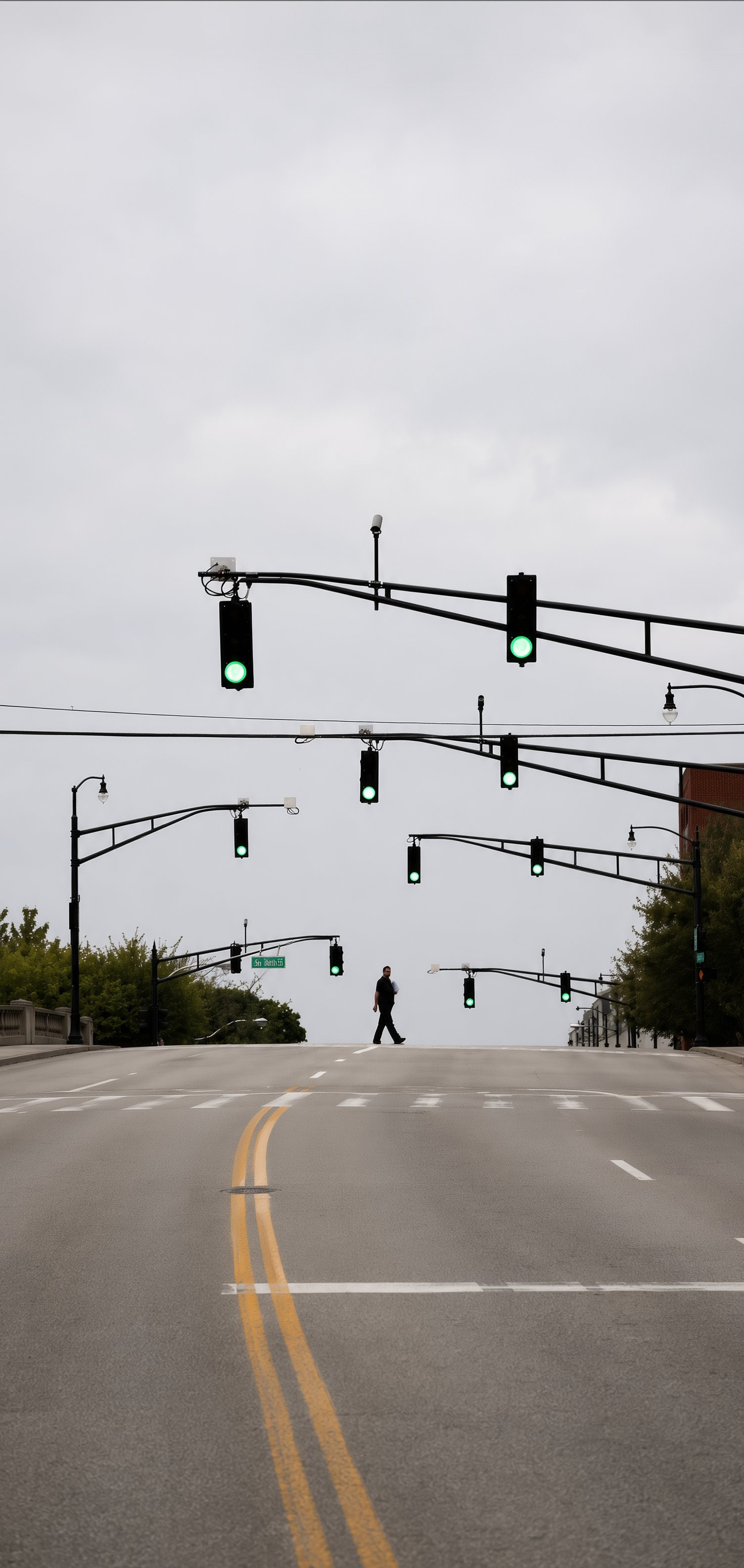 Une photographie urbaine minimaliste montre une route vide et des feux de circulation