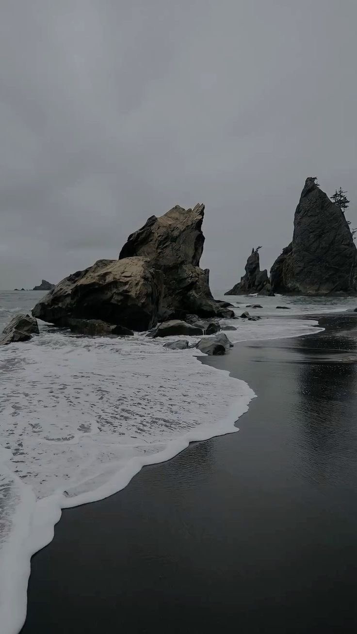 A delicada praia de areia e as enormes rochas erodidas pelo mar na costa escura destacam a beleza da solidão