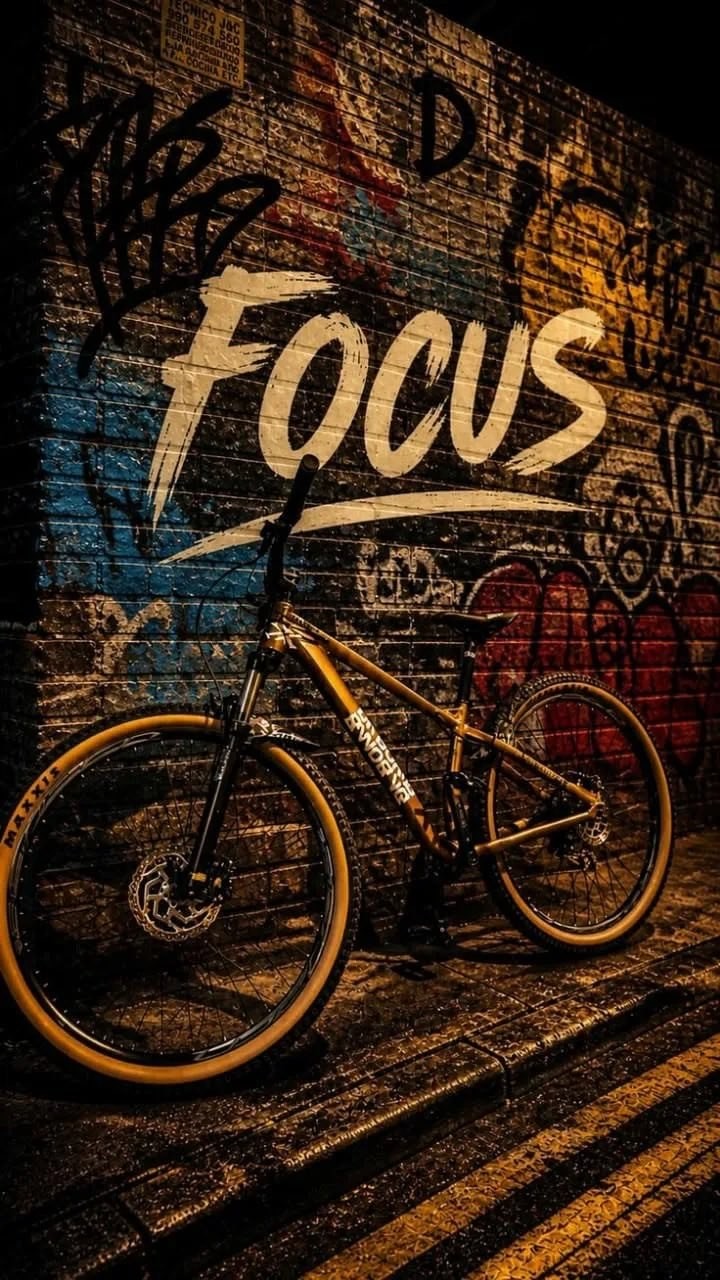 Uma bicicleta de montanha marrom se apoia em uma parede de graffiti
