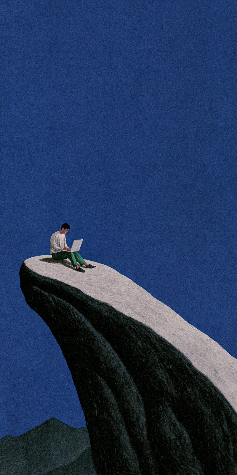 A man operates a laptop at the cliff's edge