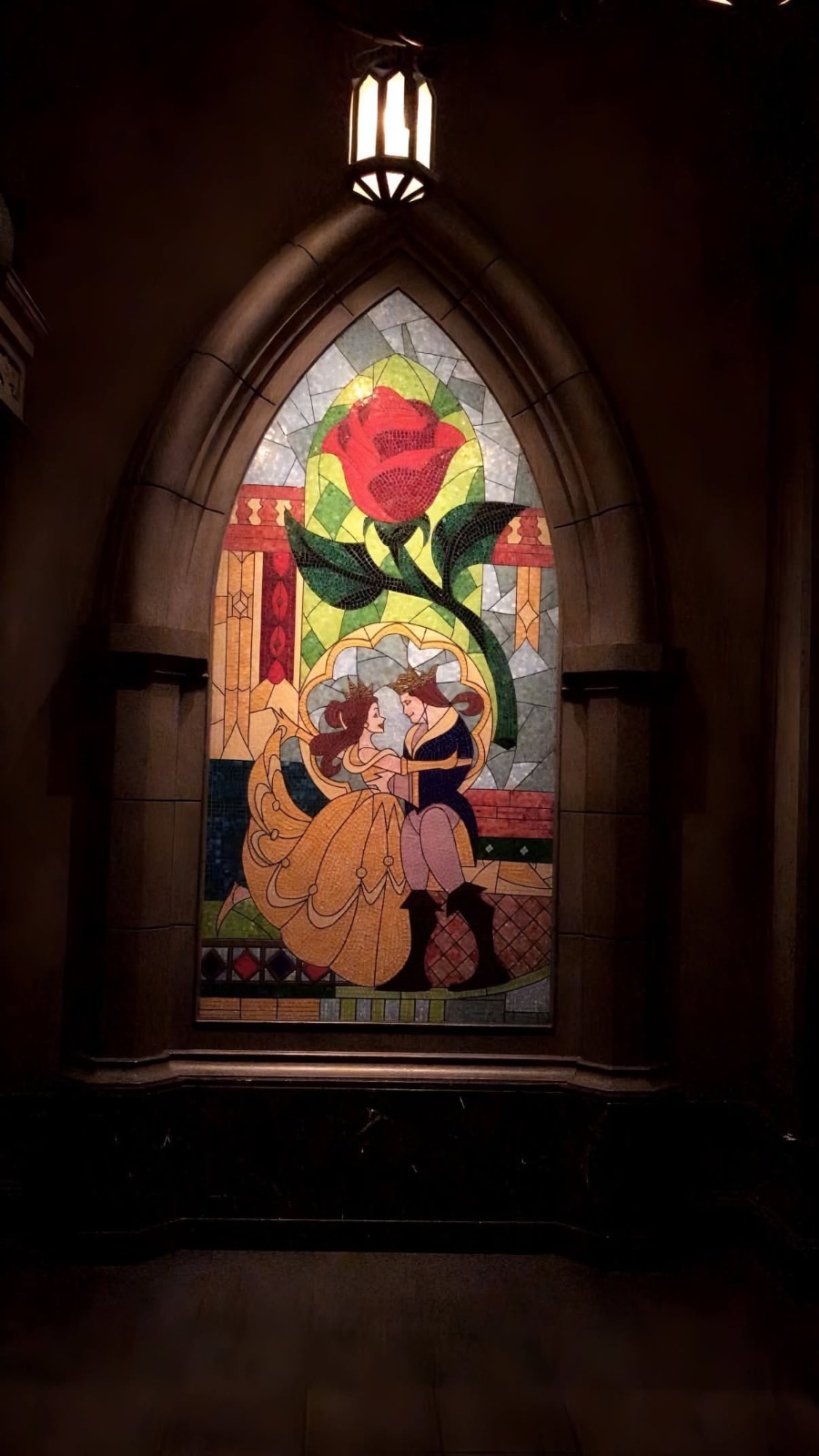 A colorful mosaic mural depicts a couple in formal attire embracing