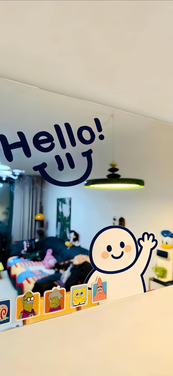 A mirror decorated with cartoon character stickers reflects a warm and bright living room
