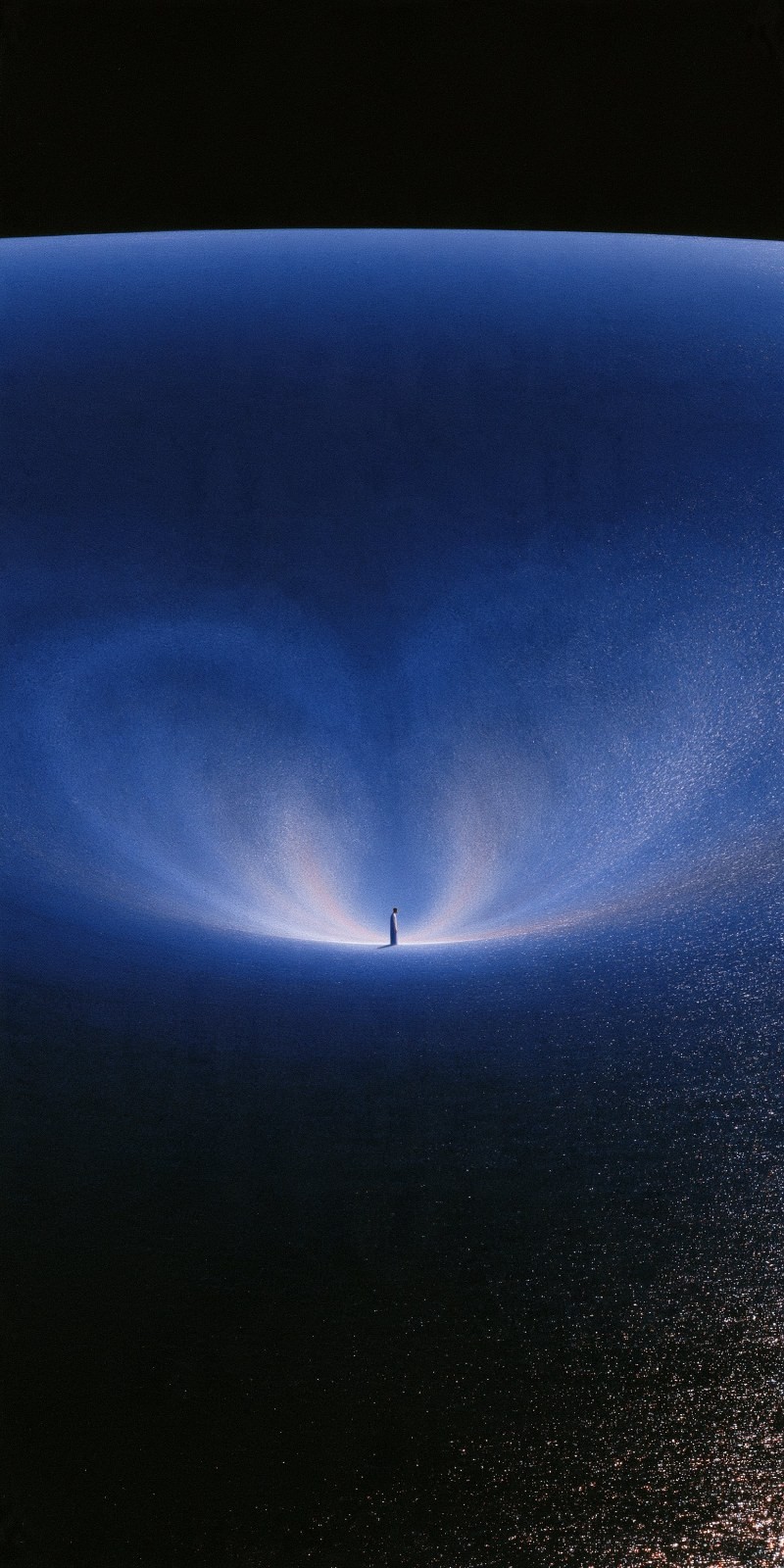 A figure stands on a blue surface with V-shaped light behind them